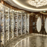 Elegant wine cellar with illuminated glass shelves and marble floor.
