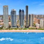 default Beachfront cityscape with tall modern buildings and turquoise ocean.