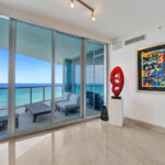 Modern living room with ocean view and artistic decor.