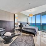 Modern bedroom with ocean view and stylish furnishings.