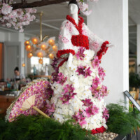 Elegant floral sculpture of a woman in a dress made of pink and white flowers.