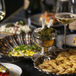 Elegant table setting with gourmet appetizers and wine glasses.