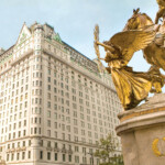 Golden angel statue with a tall historic building in the background.