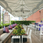 Chic outdoor lounge with cozy seating and vibrant cushions under a canopy.
