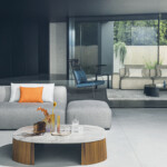Modern living room with a gray sofa and round coffee table.