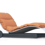 Modern black lounge chair with orange cushioned seating and ergonomic design.