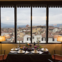 A breakfast table with a cityscape view through large windows.