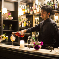 Bartender pouring a cocktail in a stylish bar setting.