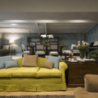 Cozy living room with a yellow sofa and warm lighting.
