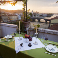 Sunset dining on a terrace overlooking a river and cityscape.