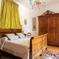 Cozy vintage bedroom with wooden furniture and bright green curtains.