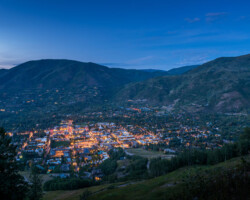 Aspen, Colorado. City lights glowing under a twilight sky in a mountainous region.