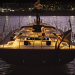 default Illuminated yacht docked at night with city lights in the background.