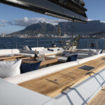 Elegant yacht deck with a scenic mountain and harbor background.