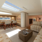 Luxurious yacht interior with elegant seating and dining area under skylights.