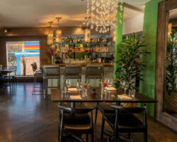 Cozy restaurant interior with wooden tables, chairs, and decorative hanging lights.