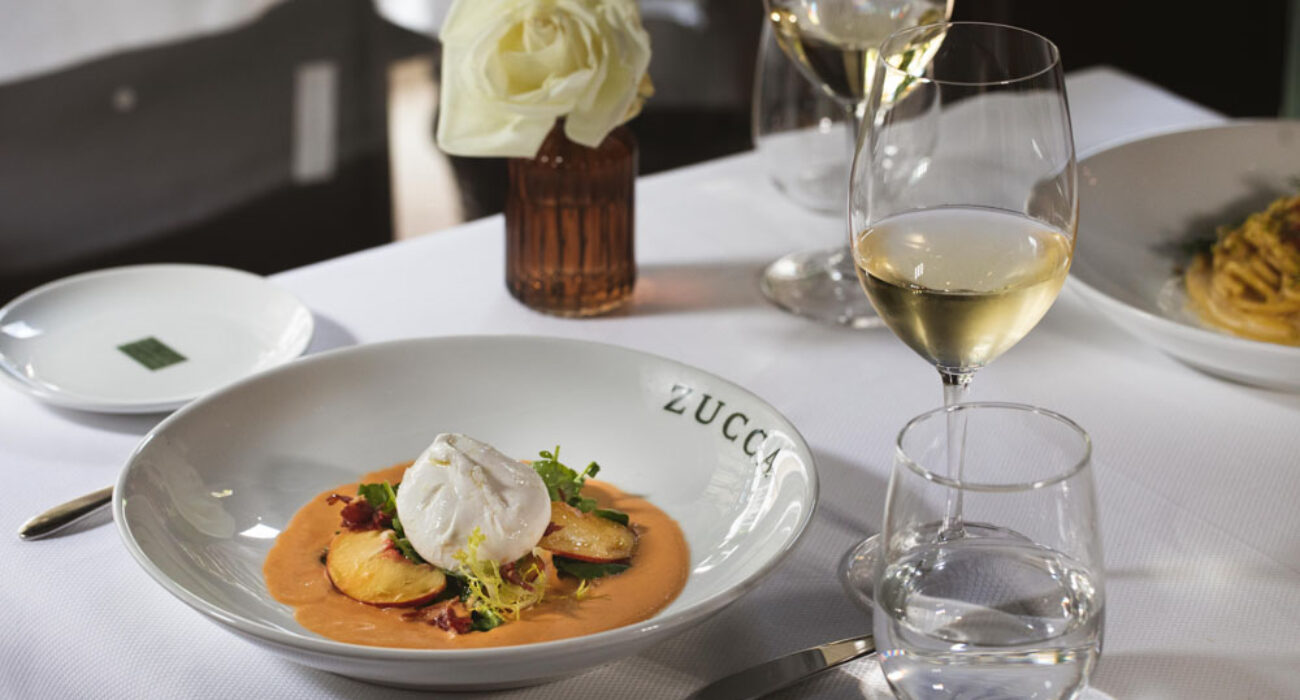 Elegant dining setup with gourmet dish and wine glasses.