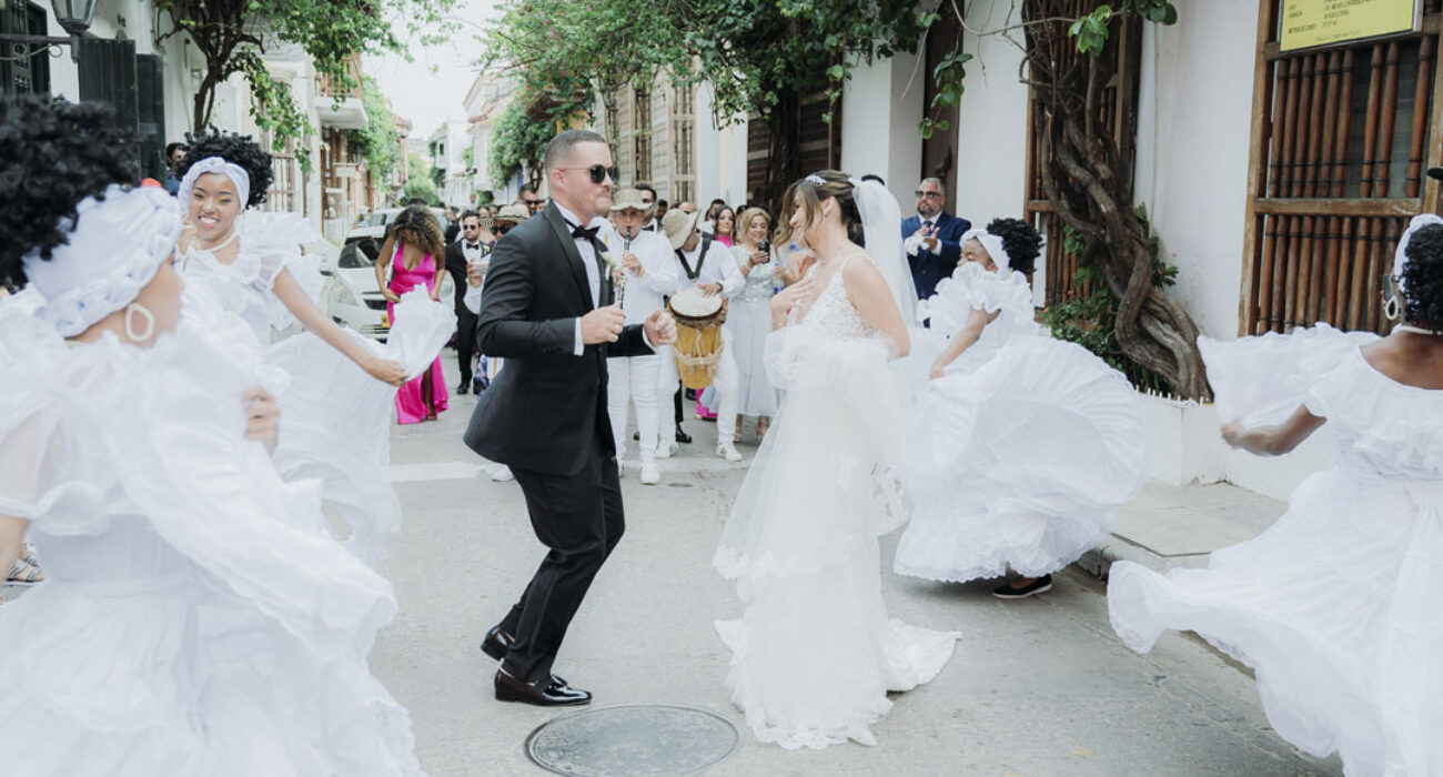 Guests joyfully dance at an outdoor wedding celebration.
