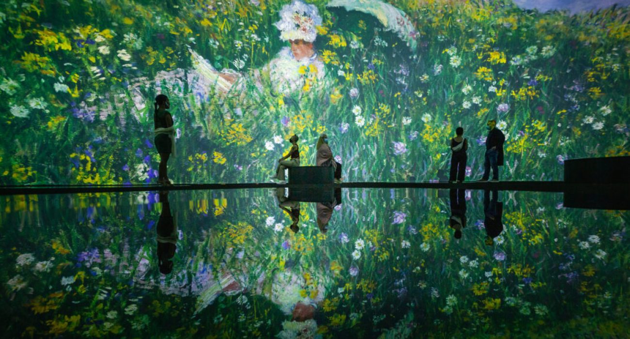 People enjoying an immersive floral art installation with reflections.