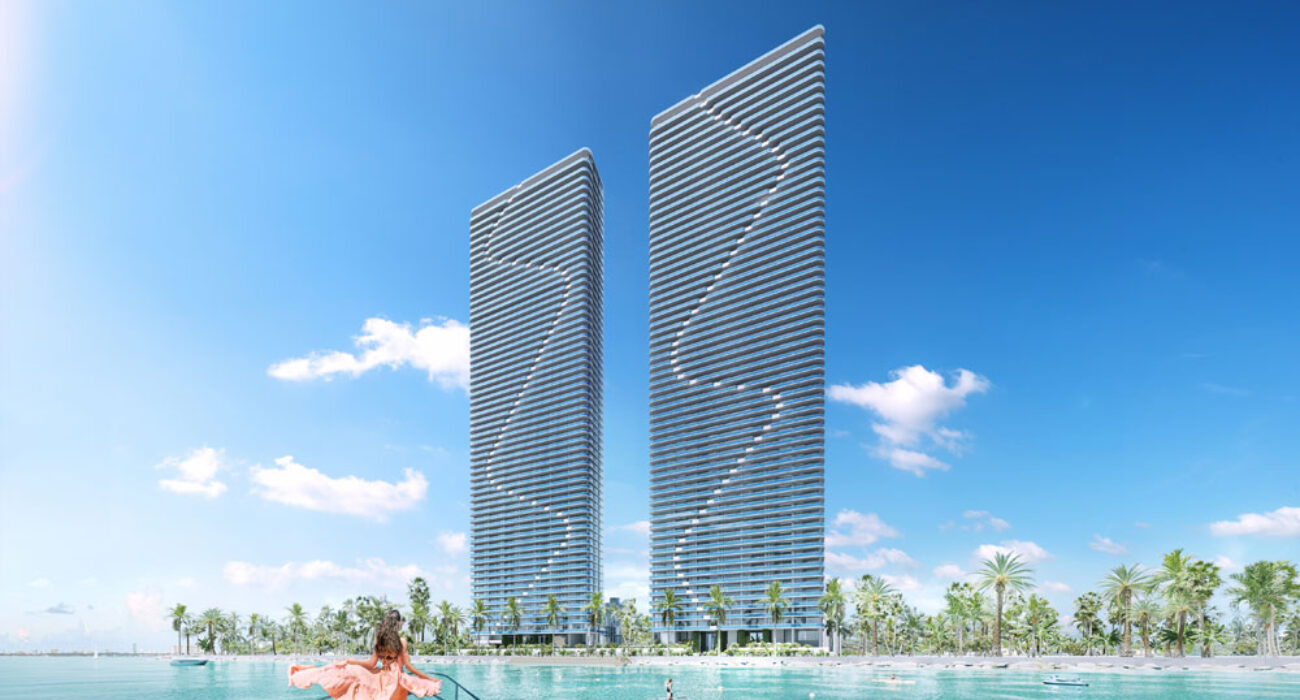 Two modern skyscrapers with a unique spiral design near a waterfront.