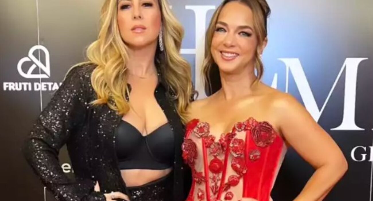 Two women dressed elegantly in black and red at a formal event.