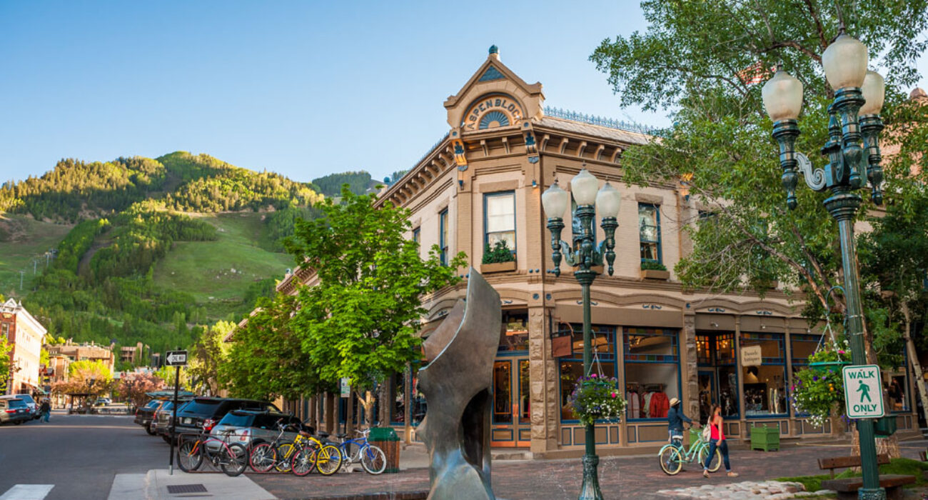 Historic building with outdoor seating in a lively city plaza.