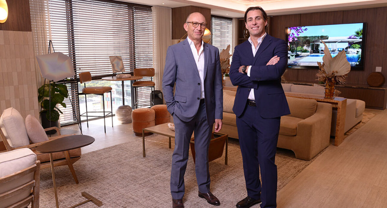 Two men in suits standing confidently in a modern office lounge.