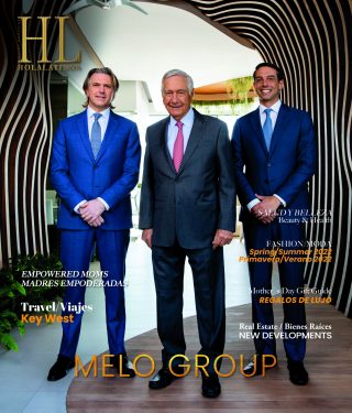 Tres hombres de traje posando profesionalmente frente a un fondo moderno con la imagen de marca de la empresa.