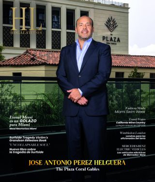 Retrato de un hombre de traje de pie al aire libre frente a un edificio.