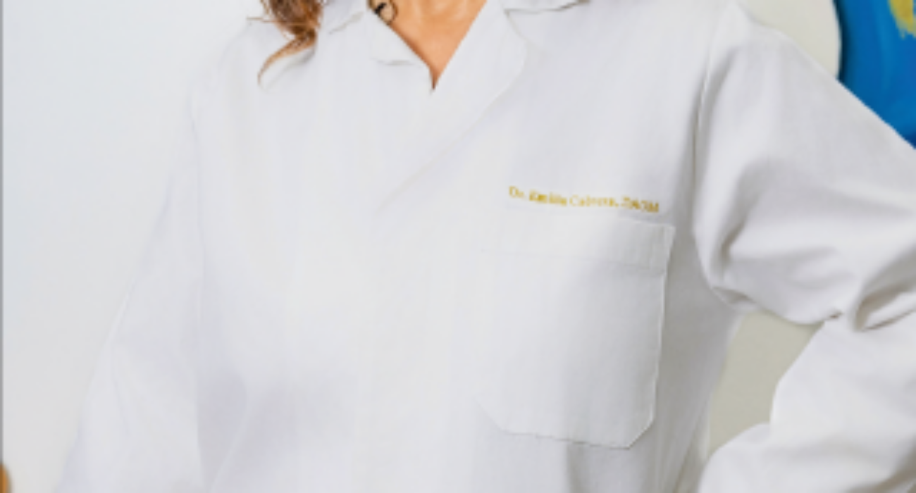 A woman in a white lab coat smiling confidently.
