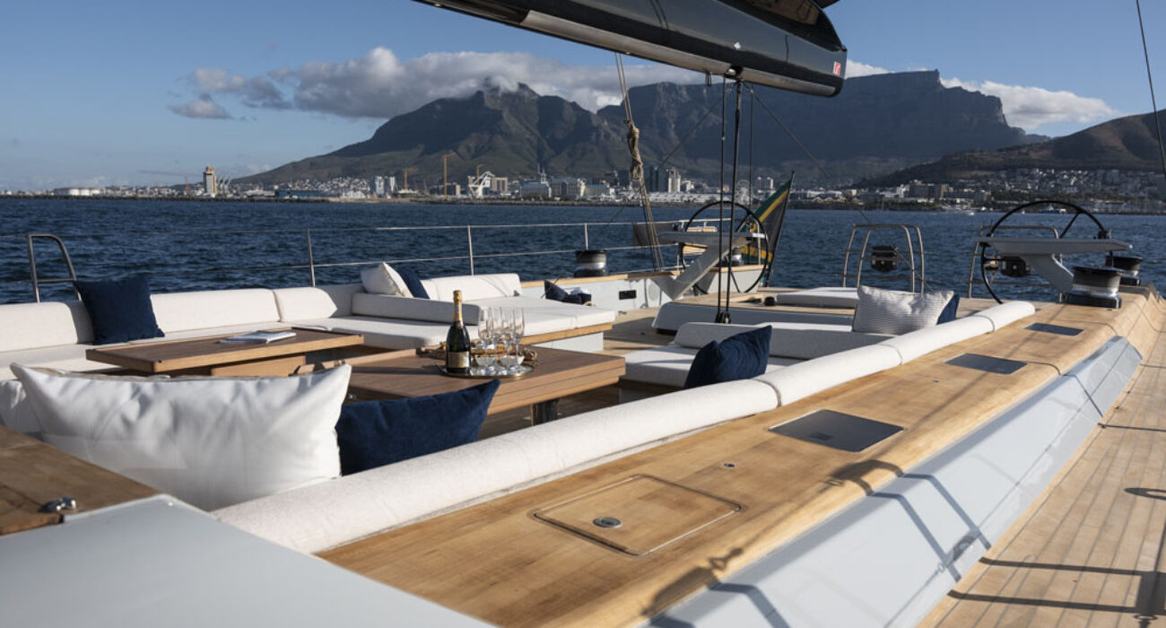 Elegant yacht deck with a scenic mountain and harbor background.